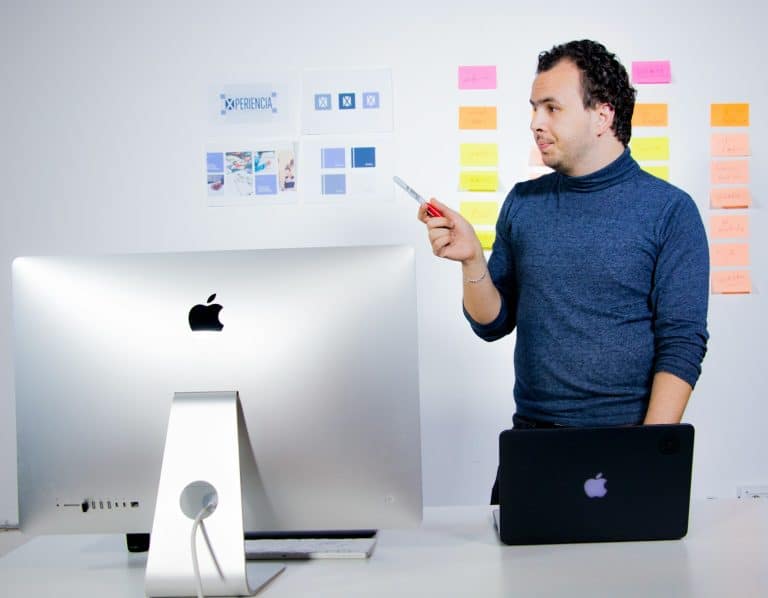 man in blue crew neck t-shirt holding black laptop computer